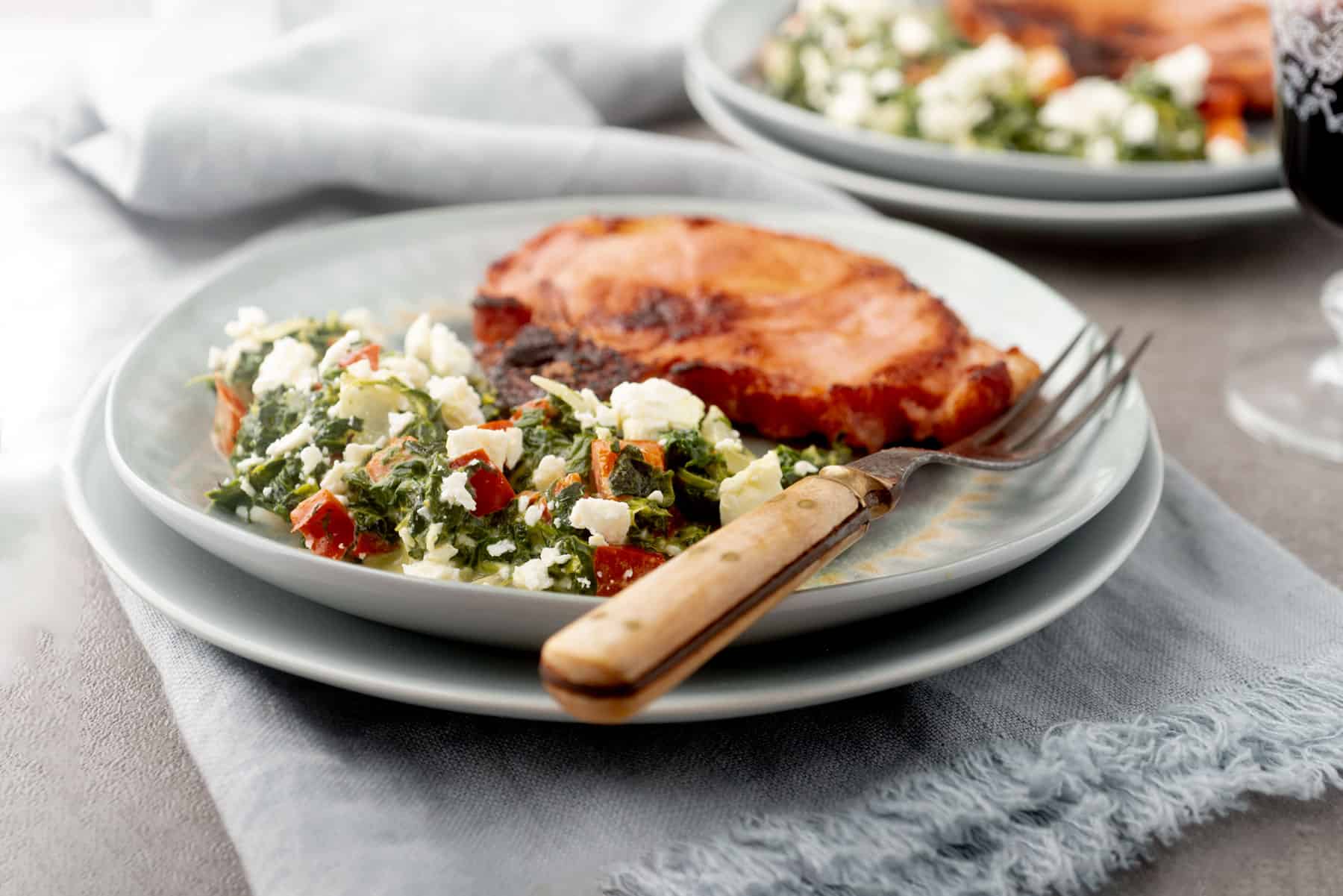Pork chops with spinach side dish.
