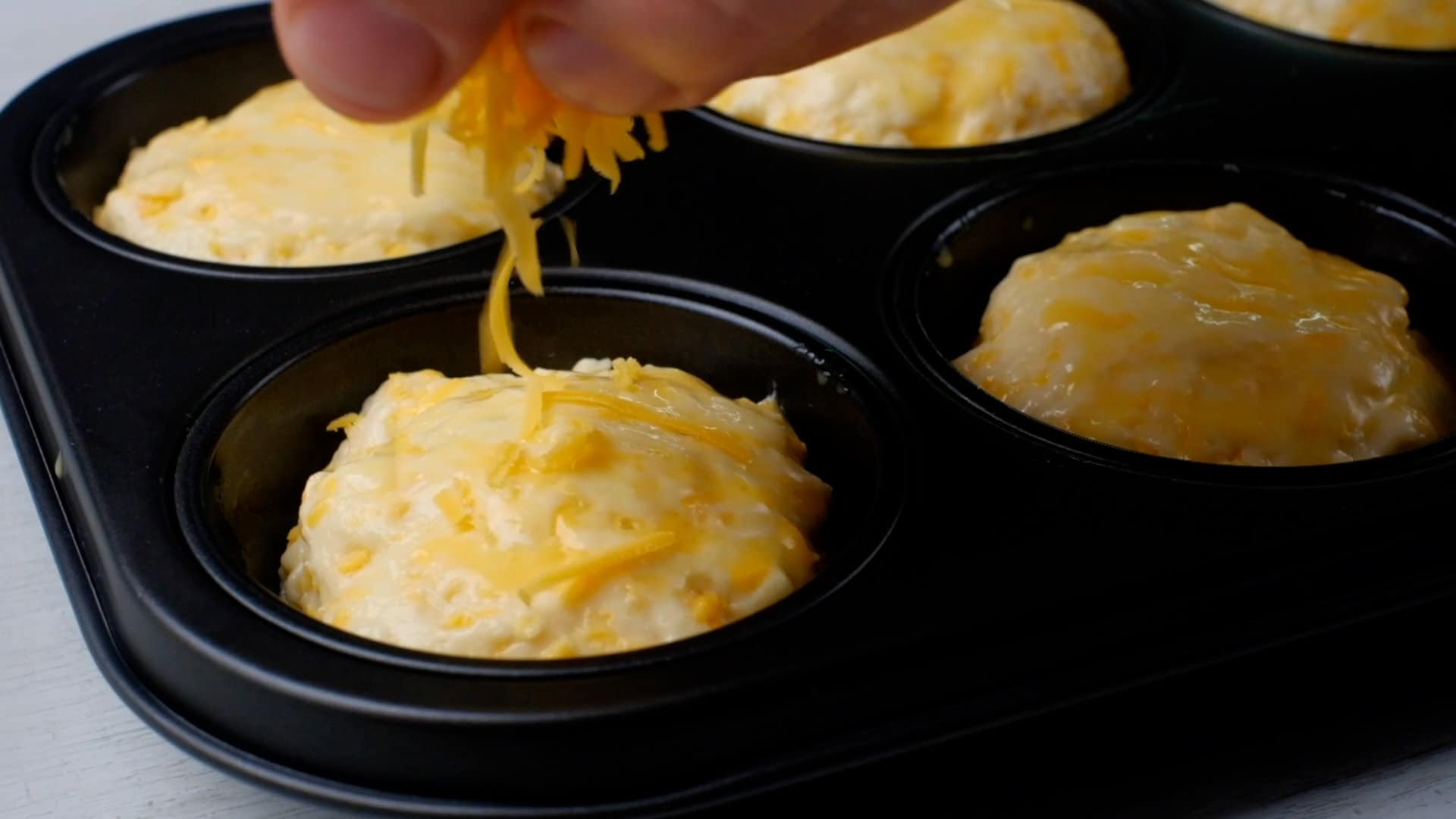 Sprinkling cheese on dough balls.