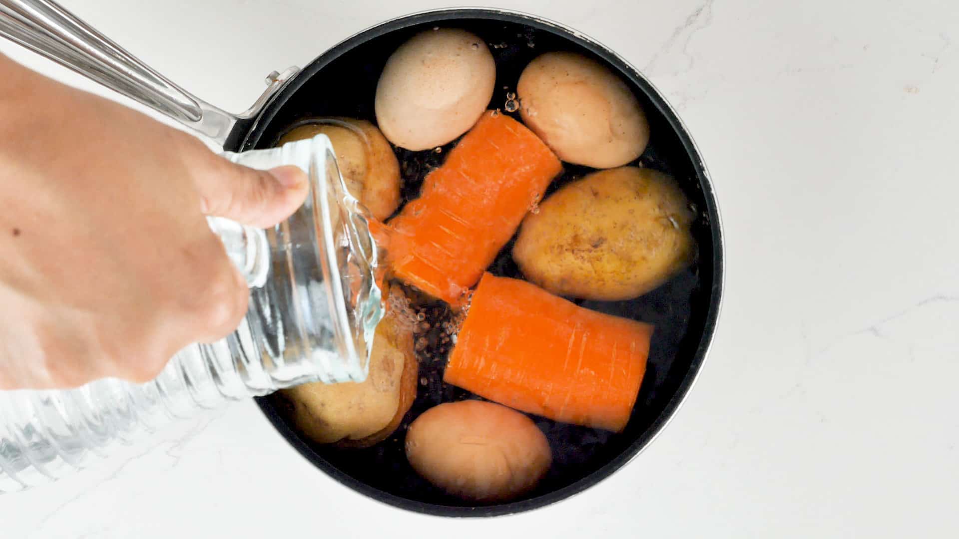 Boiling potato, egg, and carrot.