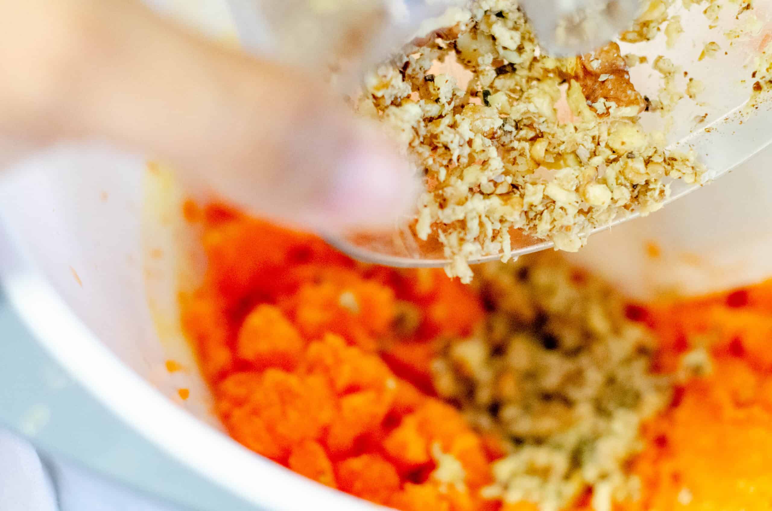 Adding walnuts to grated carrot.