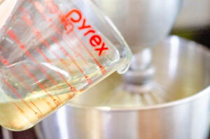 Whisking eggs, oil, and sugar.