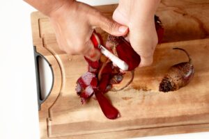 Peeling beets for beet carrot juice.