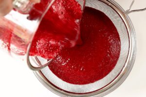 Sieving blended beets and carrots for beet carrot juice.
